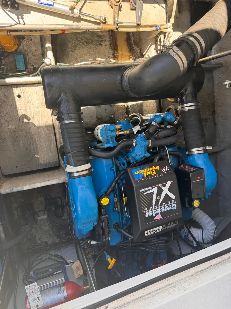 Slide: The Image of An engine compartment with a blue engine and various hoses and cables. - 22