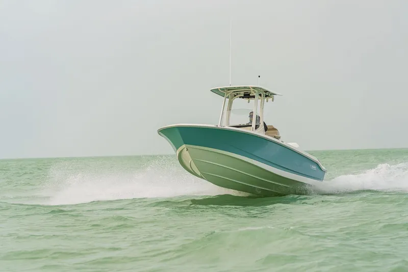 Slide: The Image of A 2027 Boston Whaler 250 Dauntless speeds across the water, featuring a turquoise hull and T-top. - 21