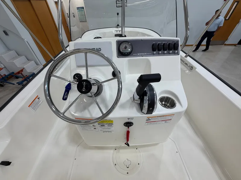Slide: The Image of The image shows the helm of a Boston Whaler 170 Montauk with a steering wheel and controls. - 18