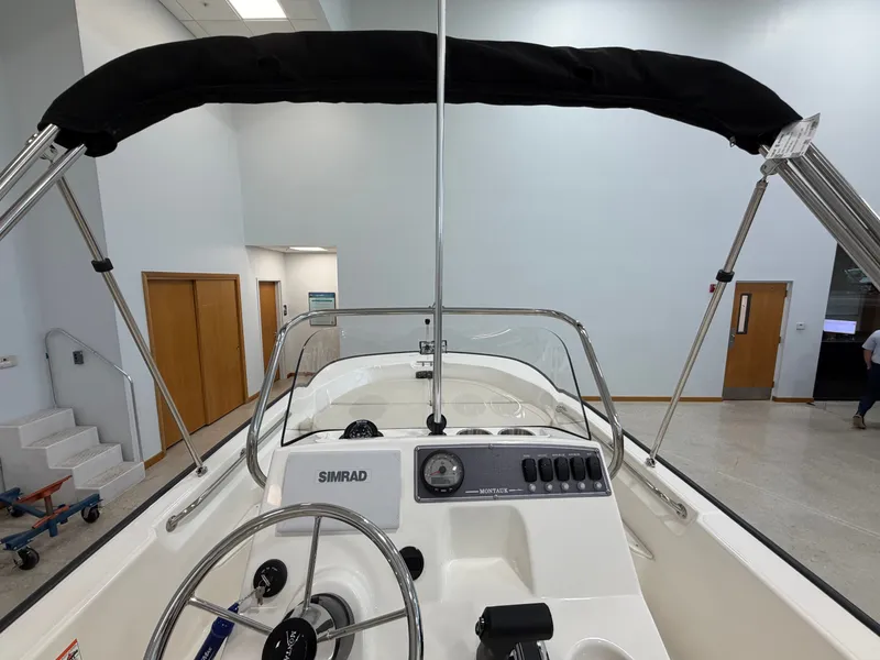 Slide: The Image of The image shows the cockpit of a Boston Whaler 170 Montauk with a steering wheel and Simrad controls. - 21