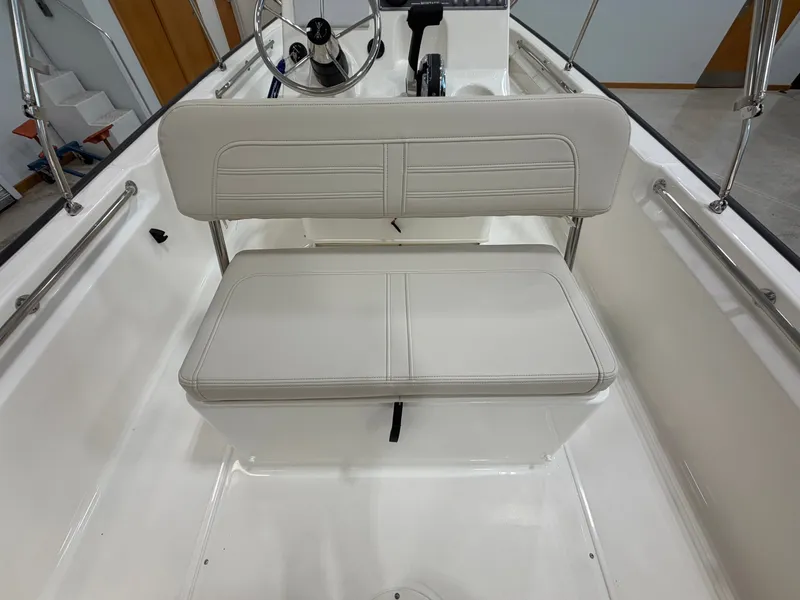 Slide: The Image of The 2027 Boston Whaler 170 Montauk features a cushioned bench seat with a backrest in the cockpit. - 24