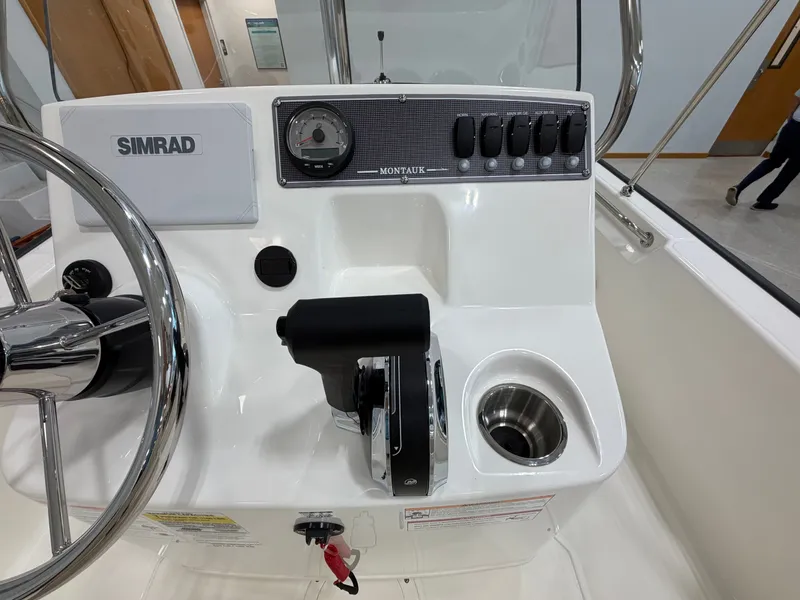Slide: The Image of The image shows the helm of a Boston Whaler 170 Montauk with Simrad electronics and throttle control. - 19