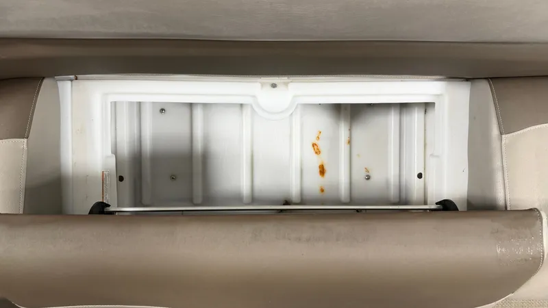 Slide: The Image of An open storage compartment with white plastic walls and some stains is visible. - 19