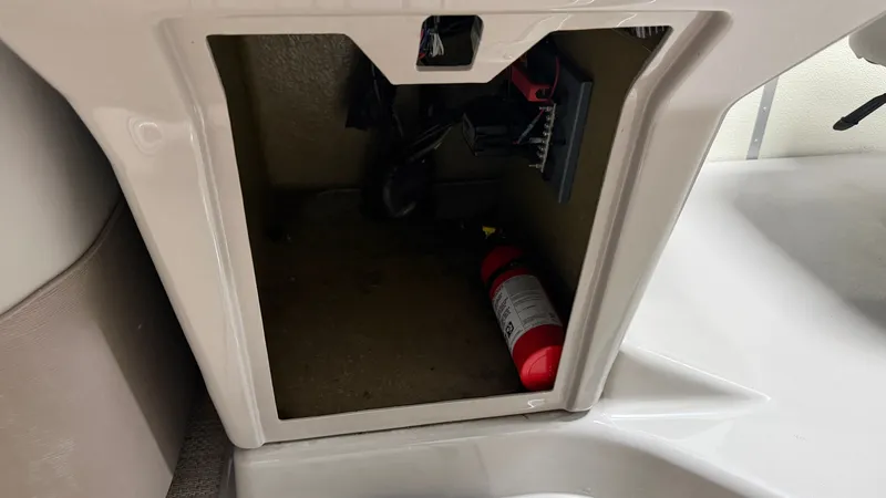 Slide: The Image of An open storage compartment with a fire extinguisher inside. - 36