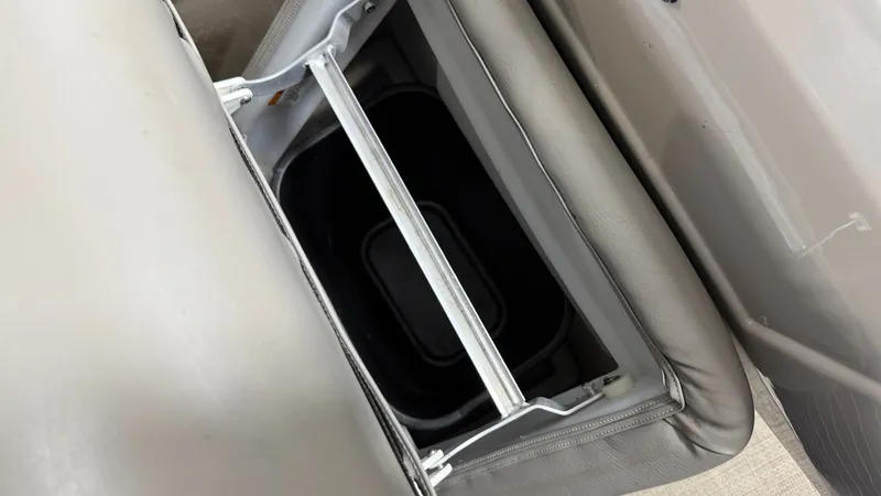 Slide: The Image of An open storage compartment within a gray seat cushion on a boat. - 24