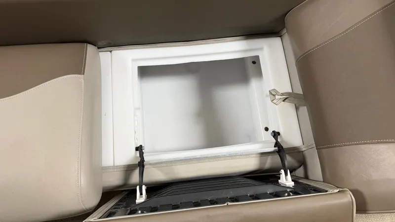 Slide: The Image of An open storage compartment in a boat with beige upholstery. - 22
