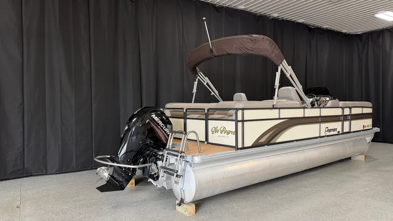 Slide: The Image of 2014 Premier 240 Sunsation SL pontoon boat with outboard motor and bimini top, in a showroom. - 2