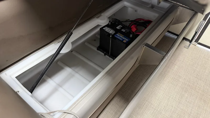 Slide: The Image of An open storage compartment with a battery inside a boat. - 49