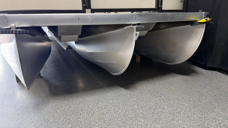 Slide: The Image of Underside of a pontoon boat with three aluminum hulls on a gray floor. - 9