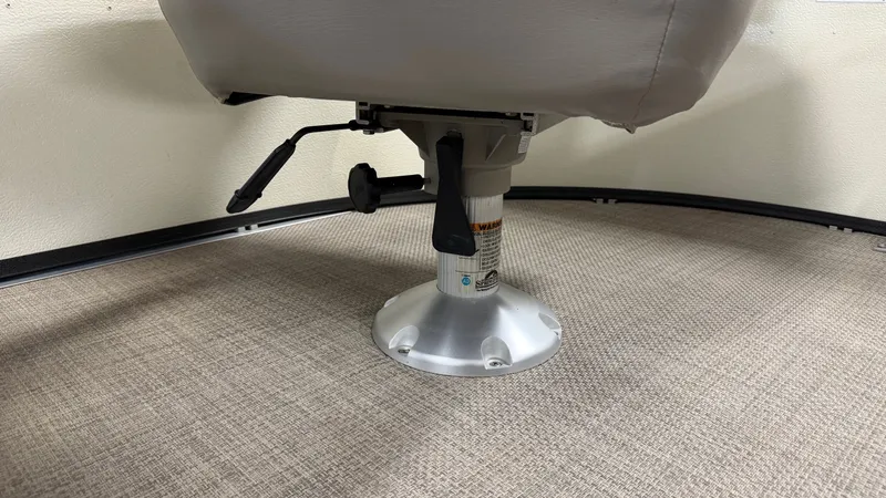 Slide: The Image of A swivel boat seat on carpeted flooring, featuring a lever for height adjustment. - 28