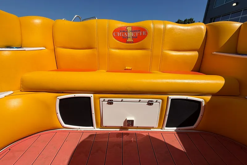 Slide: The Image of Yellow seating on a 2002 Cigarette 35' Cafe Racer boat, featuring branded upholstery. - 11