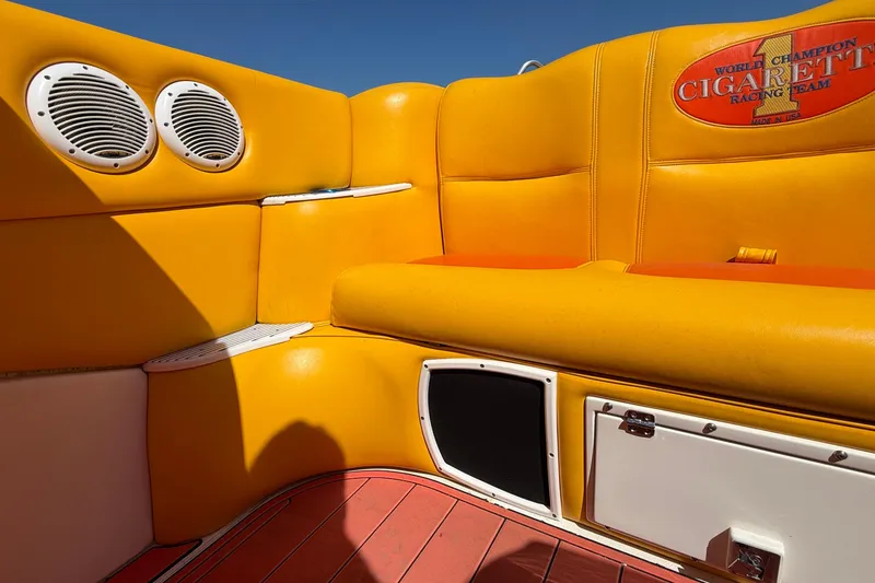 Slide: The Image of Interior of a 2002 Cigarette 35' Cafe Racer boat with vibrant yellow seating. - 12
