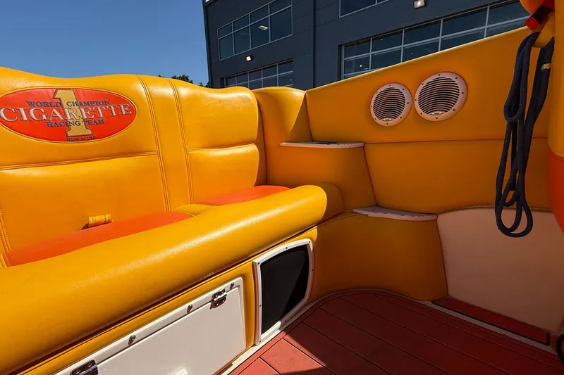 Slide: The Image of Interior of 2002 Cigarette 35' Cafe Racer with vibrant yellow seating and branded logo. - 13