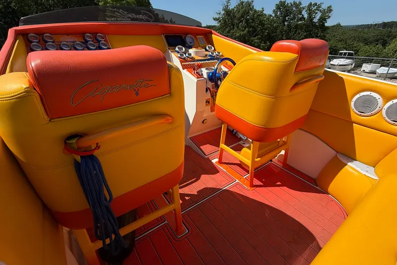 Slide: The Image of Interior of a 2002 Cigarette 35' Cafe Racer boat with vibrant orange and yellow seating. - 14