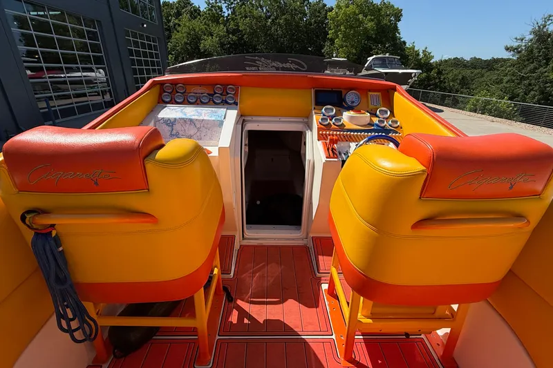 Slide: The Image of 2002 Cigarette 35' Cafe Racer boat interior with vibrant orange and yellow seating. - 15