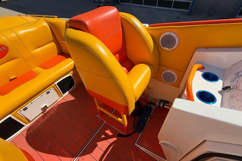 Slide: The Image of Interior of a 2002 Cigarette 35' Cafe Racer boat with vibrant orange and yellow seating. - 18