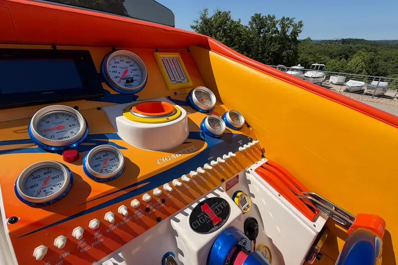 Slide: The Image of 2002 Cigarette 35' Cafe Racer dashboard with vibrant orange and yellow design, featuring multiple gauges. - 28