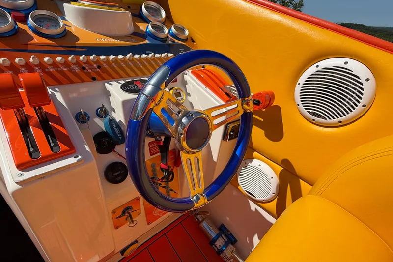 Slide: The Image of Colorful cockpit of a 2002 Cigarette 35' Cafe Racer boat with vibrant controls and steering wheel. - 30