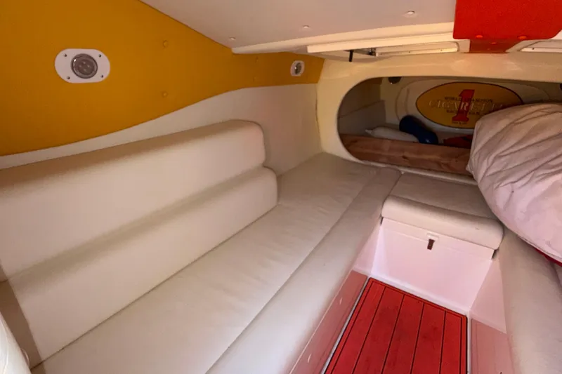 Slide: The Image of Interior cabin of a 2002 Cigarette 35' Cafe Racer boat, featuring white seating and vibrant accents. - 39