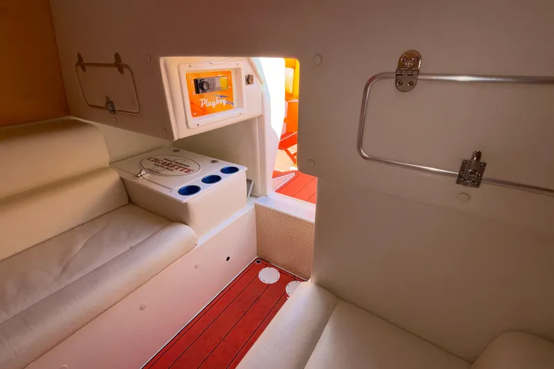 Slide: The Image of Interior of 2002 Cigarette 35' Cafe Racer boat with white seating and storage compartments. - 40