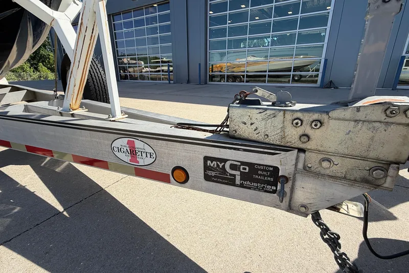 Slide: The Image of Trailer hitch of a 2002 Cigarette 35' Cafe Racer boat, parked outside a building. - 49