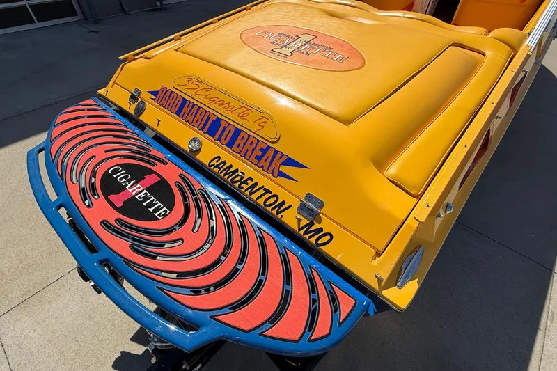 Slide: The Image of 2002 Cigarette 35' Cafe Racer boat with vibrant yellow and blue design, "Hard Habit to Break." - 8