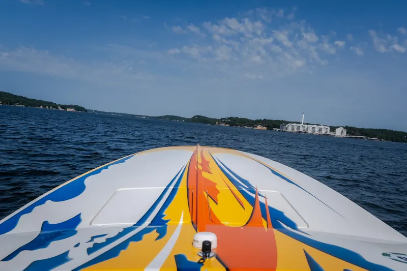 Slide: The Image of 2002 Cigarette 35' Playboy Edition boat on a lake with colorful graphics. - 9