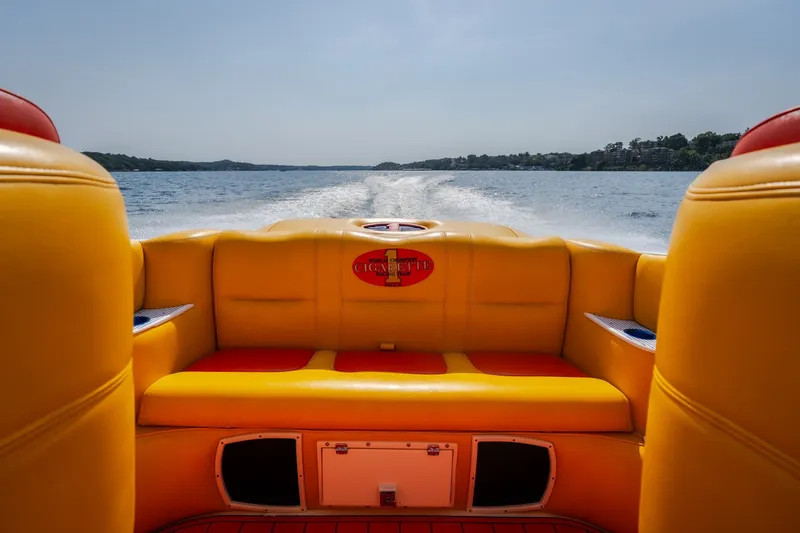 Slide: The Image of 2002 Cigarette 35' Playboy Edition boat interior with vibrant yellow seating on open water. - 10