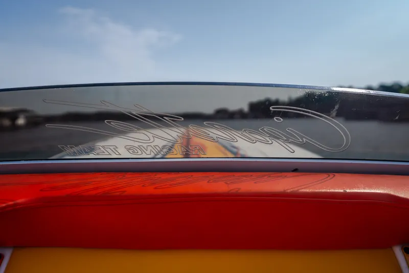 Slide: The Image of 2002 Cigarette 35' Playboy Edition boat windshield with logo, vibrant red and yellow interior. - 8