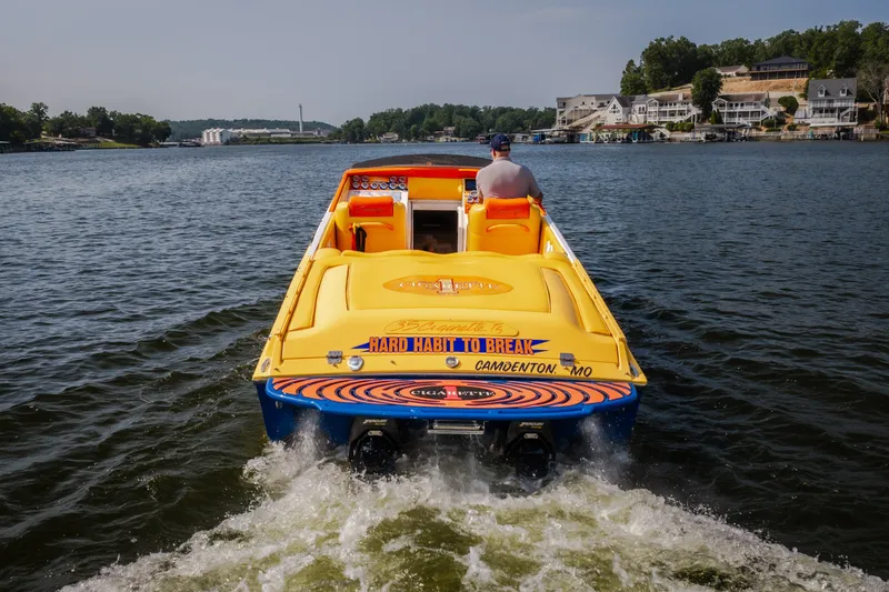 Slide: The Image of 2002 Cigarette 35' Playboy Edition speedboat cruising on a scenic lake. - 1