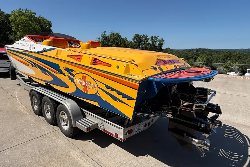 Slide: The Image of 2002 Cigarette 35' Playboy Edition speedboat on trailer, vibrant yellow and blue design. - 39
