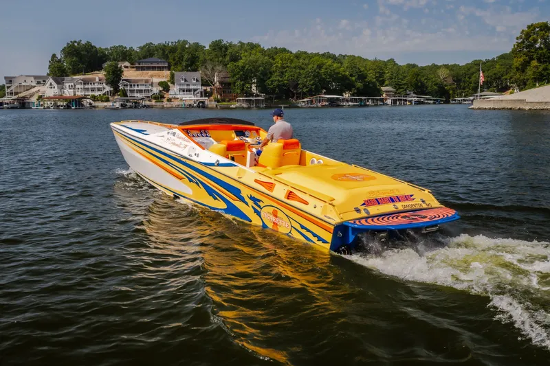 Slide: The Image of 2002 Cigarette 35' Playboy Edition speedboat cruising on a scenic lake. - 2