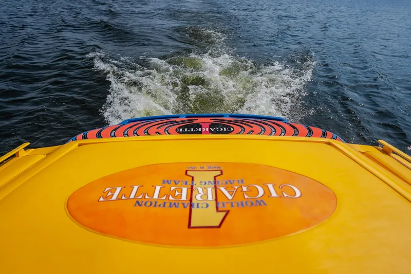 Slide: The Image of 2002 Cigarette 35' Playboy Edition speedboat on water, vibrant yellow and orange design. - 26