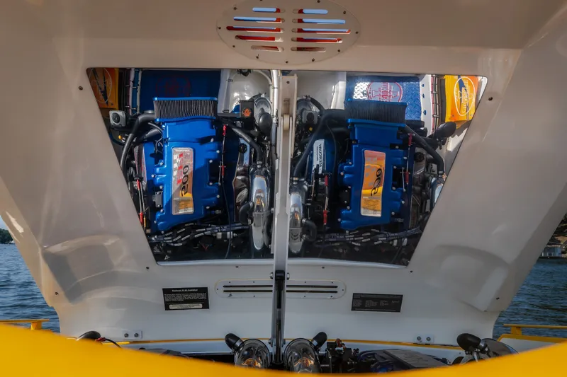 Slide: The Image of Engine compartment of a 2002 Cigarette 35' Playboy Edition boat, showcasing dual blue engines. - 14