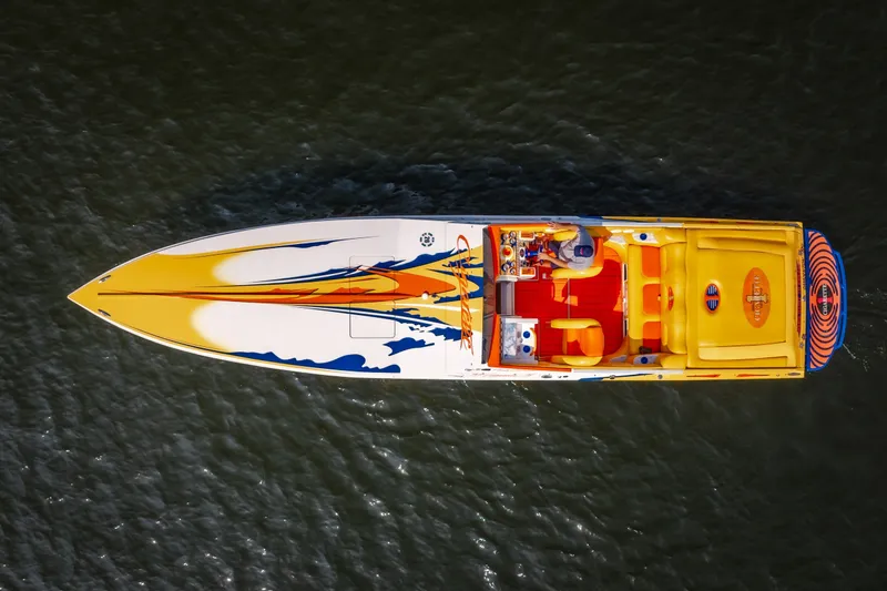 Slide: The Image of 2002 Cigarette 35' Playboy Edition boat with vibrant graphics on water. - 4