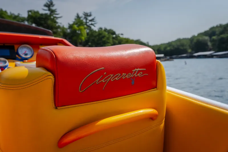 Slide: The Image of 2002 Cigarette 35' Playboy Edition boat interior with vibrant red and yellow seating. - 21