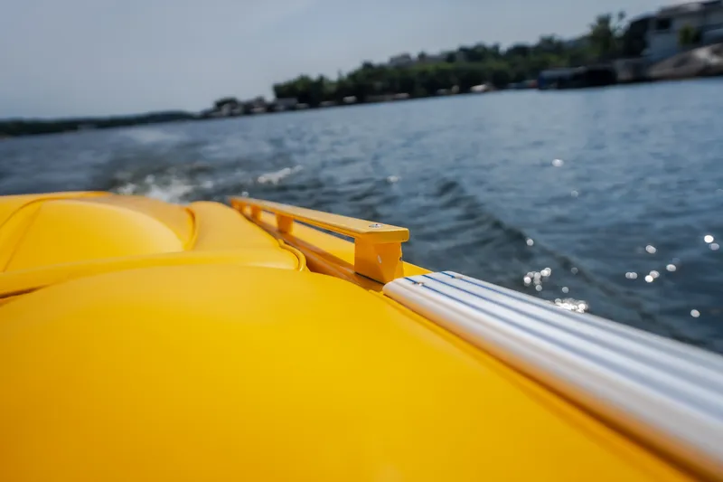 Slide: The Image of Yellow 2002 Cigarette 35' Playboy Edition boat cruising on a sunny lake. - 25
