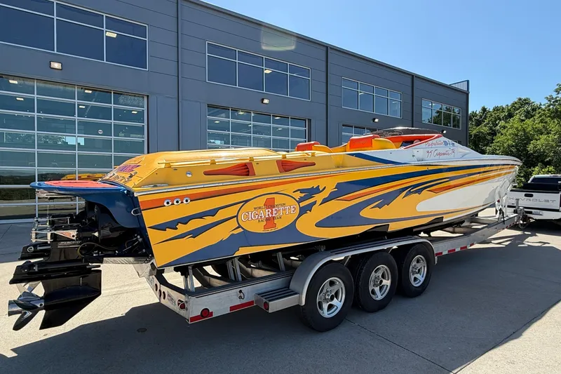 Slide: The Image of 2002 Cigarette 35' Playboy Edition speedboat on trailer, vibrant yellow and blue design. - 37