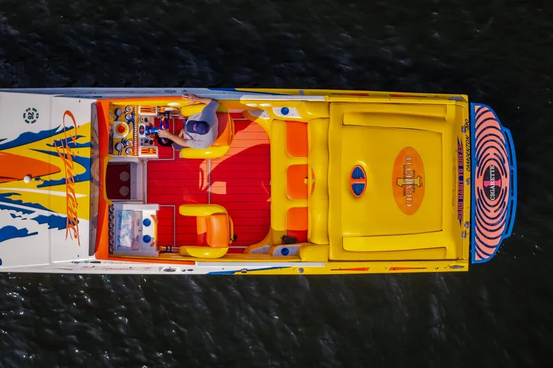 Slide: The Image of Aerial view of 2002 Cigarette 35' Playboy Edition speedboat with vibrant yellow and orange design. - 5