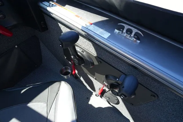 Slide: The Image of Close-up of the control console in a 2024 Lund 2075 Fisherman with two levers and a cup holder. - 35