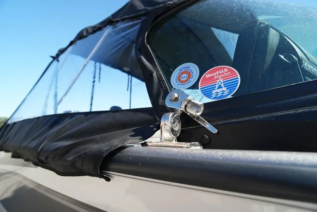 Slide: The Image of Close-up of a boat window with stickers and a black cover. - 39