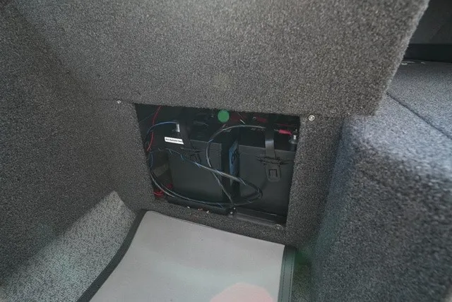 Slide: The Image of A battery compartment in a boat with gray carpeted flooring. - 29