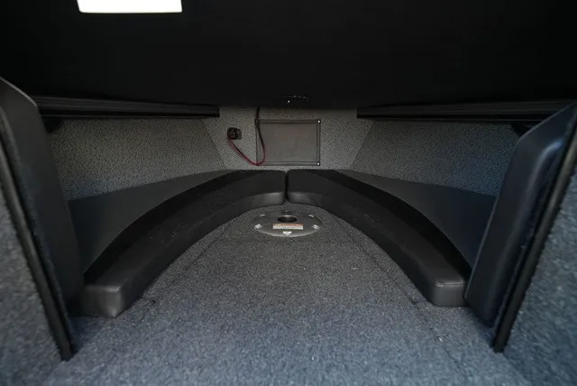Slide: The Image of Interior view of a boat with gray carpet flooring and black cushioning. - 38