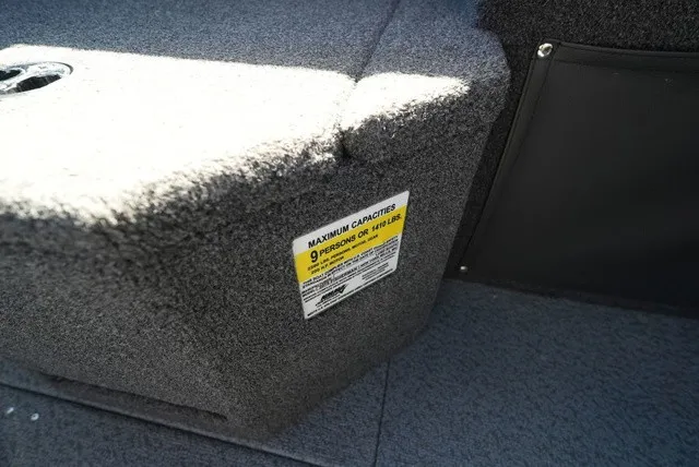 Slide: The Image of Close-up of a boat interior with gray carpeting and a capacity label for 9 people. - 36