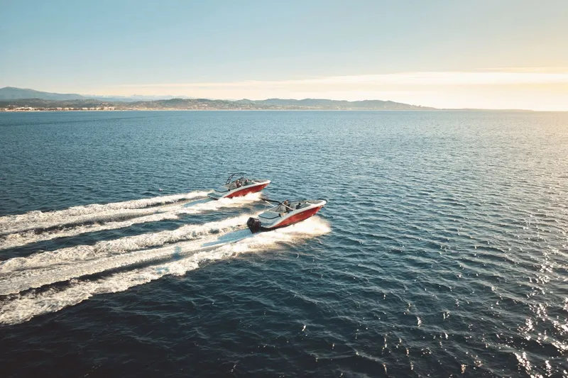 Slide: The Image of Two Sea Ray SPX 210 Outboard boats speed across the open sea under calm weather. - 25