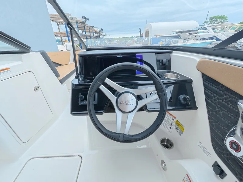 Slide: The Image of The image shows the cockpit of a Sea Ray SPX 210 Outboard with a modern steering wheel and dashboard. - 16
