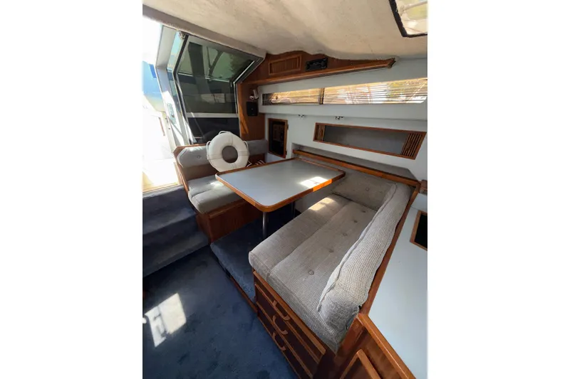 Slide: The Image of Interior of 1987 Sea Ray 300 Weekender boat with cozy seating and dining area. - 12