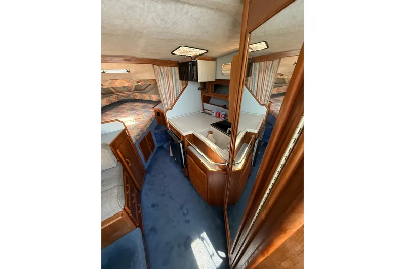 Slide: The Image of Interior of 1987 Sea Ray 300 Weekender boat with cozy cabin and kitchenette. - 14