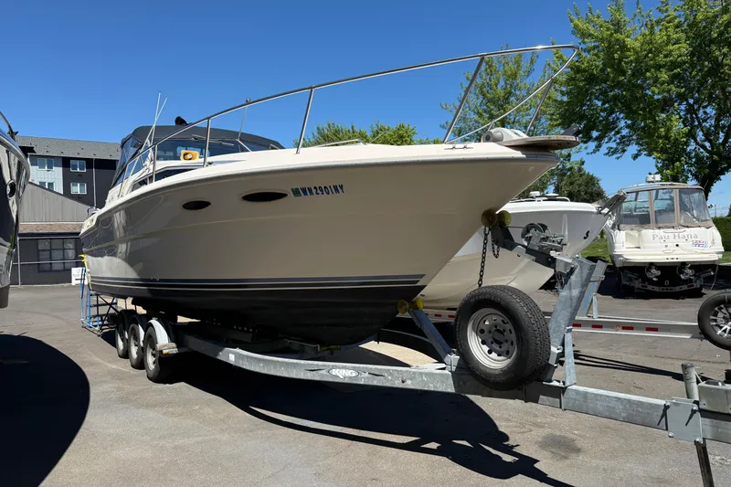 Slide: The Image of 1987 Sea Ray 300 Weekender boat on trailer, parked outdoors under clear sky. - 17