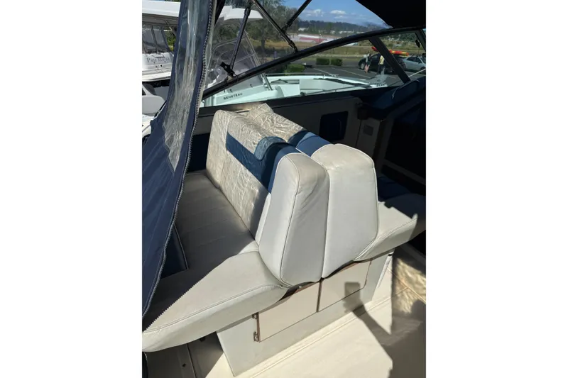 Slide: The Image of 1987 Sea Ray 300 Weekender interior with cushioned seating and blue accents. - 4